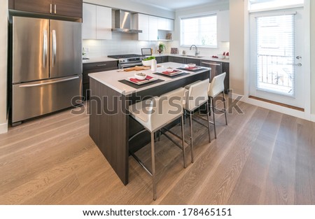 Interior design of a luxury modern kitchen with nicely decorated and served island table.