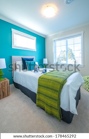 Modern comfortable, nicely decorated children bedroom painted in turquoise. Interior design.