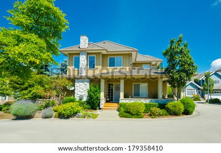 Big custom made luxury house with nicely  trimmed and landscaped front yard in the suburbs of Vancouver, Canada.