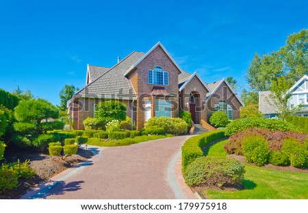 Big custom made luxury house with nicely landscaped front yard and long and wide nicely paved driveway in the suburbs of Vancouver, Canada.