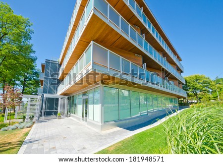 Perspective, outlook of the modern glass, wood and steel building, house with the balconies on perimeter.  Exterior design.