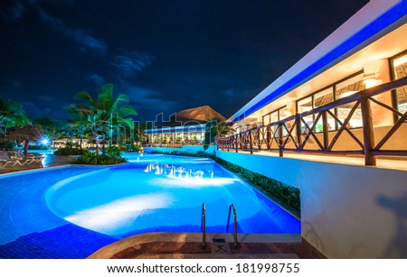 Swimming pool at promenade and restaurant at luxury caribbean resort at night, dawn time. Bahia Principe, Riviera Maya, Mexico.