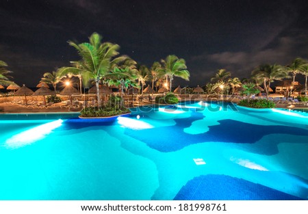 e of promenade between swimming pool and a restaurant at luxury caribbean resort at night, dawn time. Bahia Principe, Riviera Maya, Mexico.