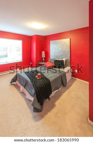 Modern comfortable, nicely decorated, bedroom painted in red. Interior design.