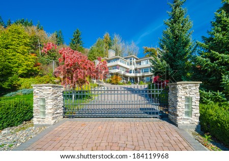 Big custom made luxury house behind the gates with nicely paved driveway gin the suburbs of Vancouver, Canada.