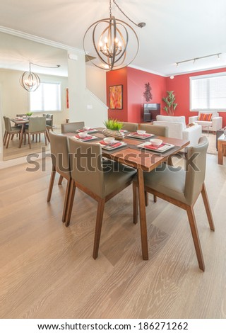 Luxury living suite : nicely decorated dining table and the living room at the back. Interior design. Vertical.