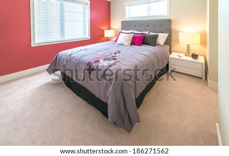 Modern and elegant luxury master bedroom with red color wall. Interior design.