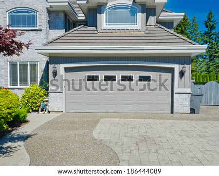 Big custom made double doors garage with nicely paved long and wide driveway in the suburbs of Vancouver, Canada.
