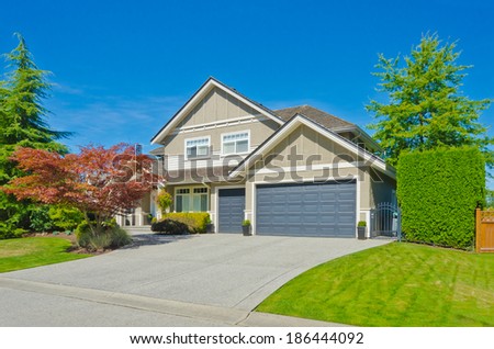 Big custom made luxury house with nicely landscaped front yard, triple doors garage and long and wide driveway in the suburbs of Vancouver, Canada.