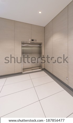 Brushed and shiny metal elevator door in a minimalistic style. Building interior design. Vertical.
