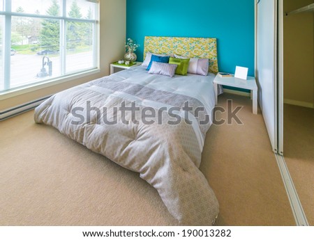 Modern comfortable, nicely decorated children bedroom painted in blue and the tray with the tea, coffee set on the bed. Interior design.