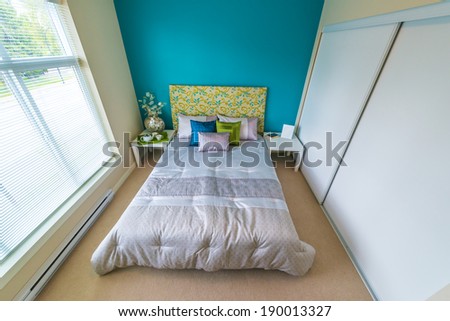 Modern comfortable, nicely decorated children bedroom painted in blue and the tray with the tea, coffee set on the bed. Interior design.