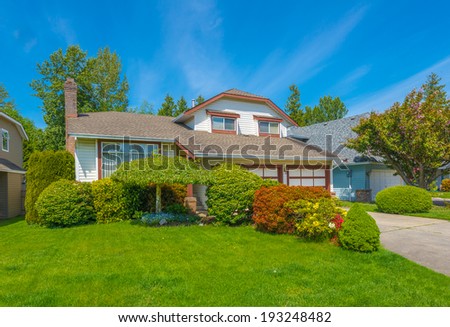 Custom built luxury house with nicely trimmed front yard, lawn and long driveway  to garage in residential neighborhood. Vancouver Canada.