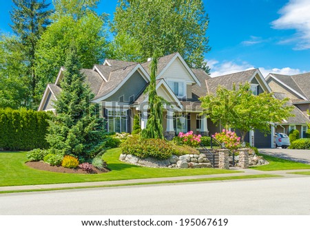 Big custom made luxury house with nicely trimmed and landscaped front yard  in the suburb of Vancouver, Canada.g