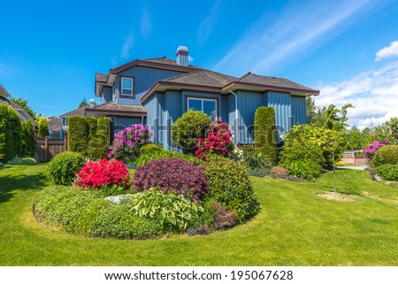 Big custom made luxury house with nicely trimmed and landscaped front yard  in the suburb of Vancouver, Canada.g
