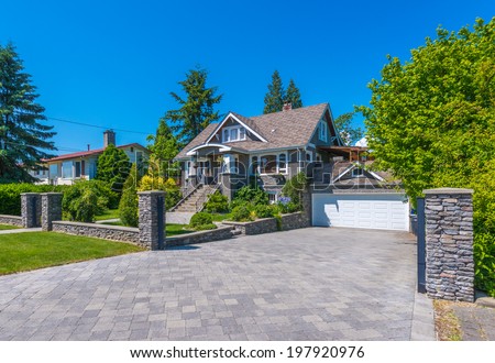 Big custom made luxury house with nicely paved driveway to the double doors garage in the suburb of Vancouver, Canada.