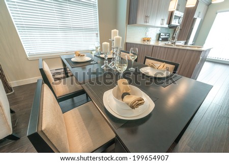 Luxury living site. Nicely decorated and served dining table with napkins and candle holders. Interior design of a brand new house.