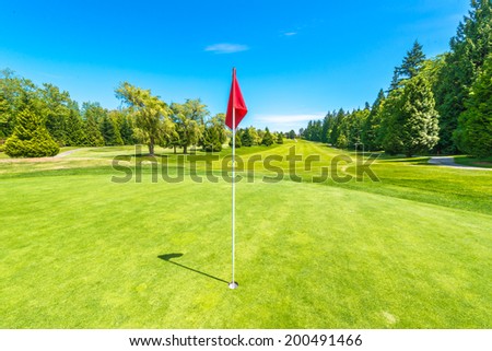 Red flag at the beautiful golf course in a sunny day. Canada, Vancouver.
