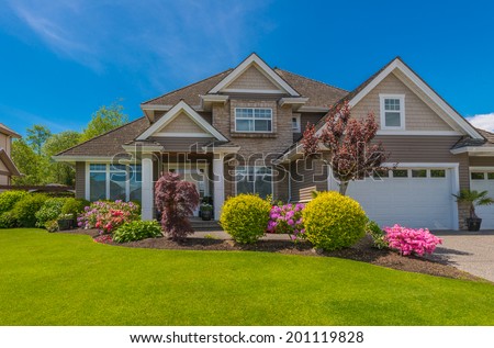 Big custom made luxury house with nicely trimmed and  landscaped front yard  in the suburb of Vancouver, Canada.