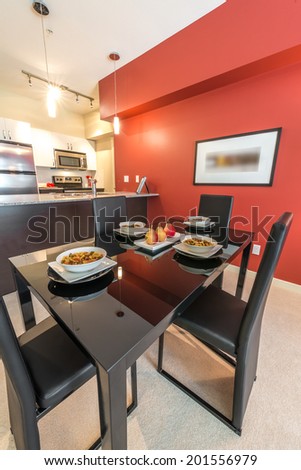Luxury living suite with red walls: nicely decorated and served with pasta and fruits dining table. Interior design.