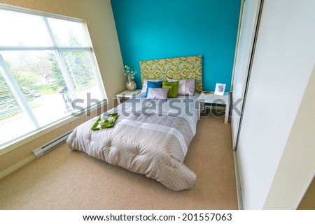 Modern comfortable, nicely decorated master, children bedroom painted in blue, and tray with the tea, coffee set on the bed. Interior design.