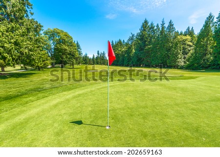 Red flag at the beautiful golf course in a sunny day. Canada, Vancouver.
