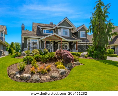 Big custom made luxury house with nicely trimmed and  landscaped front yard in the suburb of Vancouver, Canada. Landscape design.