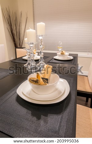 Napkins and candle holders on the nicely decorated and served dining table. Interior design of a brand new house.