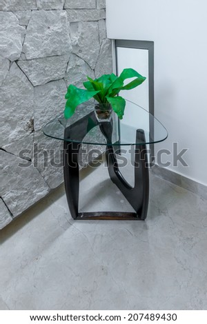 Decorative vase with plant on the modern table in in the corner of the room.Interior design. Vertical.