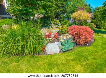 Flowers and stones in front of the house, front yard. Landscape design.