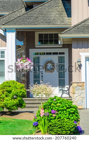 Entrance of a house with nicely trimmed and landscaped front yard.