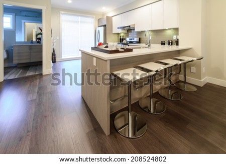 Interior design of a luxury modern kitchen with some sits in a bar style at the island counter.