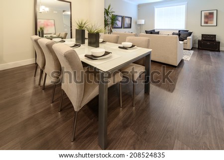 Nicely decorated dining table and the living room at the back. Interior design.