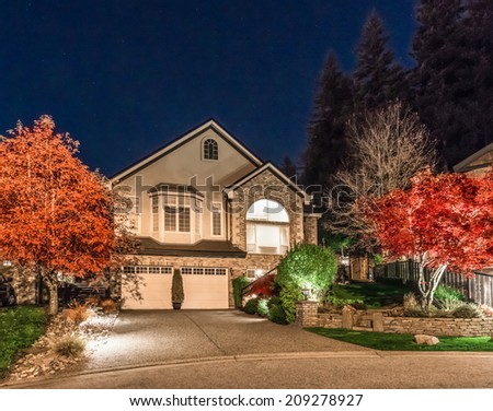Big luxury house with double doors garage at night, disk, sunset, sunrise time in suburbs of Vancouver, Canada.