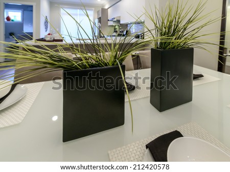 Nicely decorated dining table with two decorative vases with plants. Interior design.