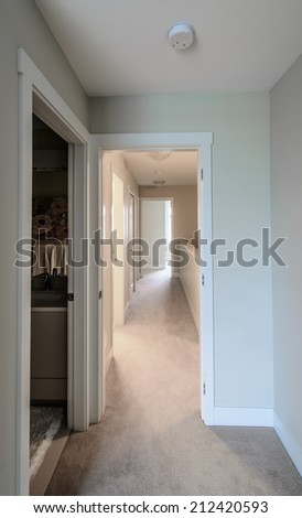 A corridor on the upper level of a house with  the rooms at the end. Interior design. Vertical.