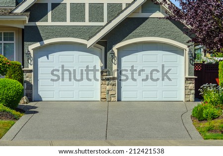 Double doors garage with wide long driveway.