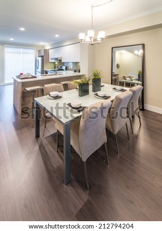 Nicely decorated dining table and the kitchen at the back. Interior design. Vertical.