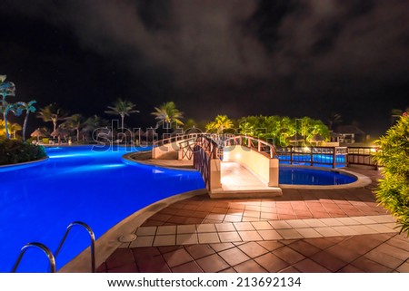 Bridge over the swimming pool at luxury caribbean resort at night, dawn time. Bahia Principe, Riviera Maya, Mexican Resort.