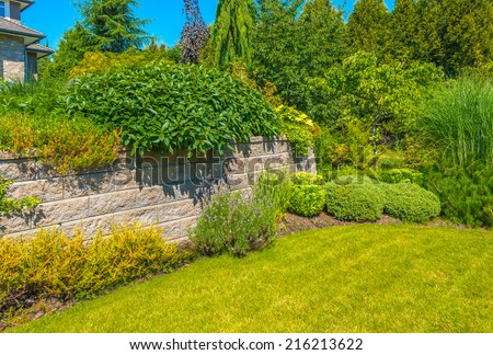 Nicely decorated front yard. Flowers and stones in front of the house. Landscape design.