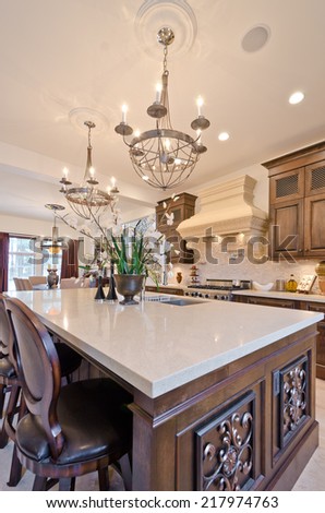 Interior design of a luxury modern kitchen with some flowers in the vase on the counter.