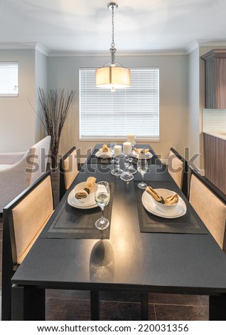 Luxury dining site. Nicely decorated dining table with napkins on the plates. Interior design of a brand new house. Vertical.