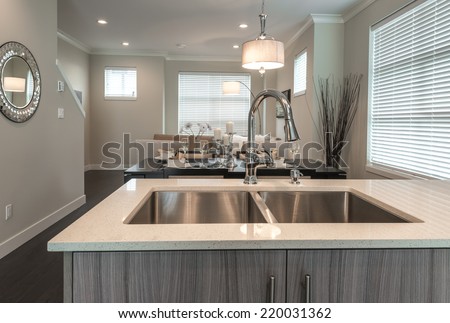 Modern kitchen sink and the living room at the back in a brand new house. Interior design.
