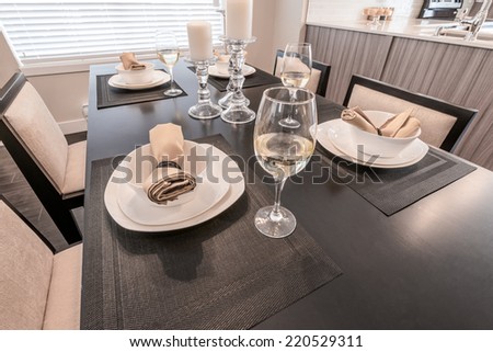 Luxury living site. Nicely decorated and served dining table with napkins and candle holders. Interior design of a brand new house. Interior design.