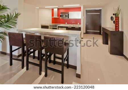 Luxury modern living suite with  nicely decorated dining table and red walls kitchen at the back. Interior design of a brand new house.