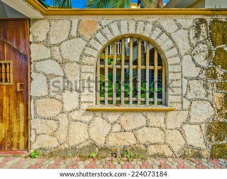 Rustic, old looking window on the stone wall. Mediterranean, Caribbean style.