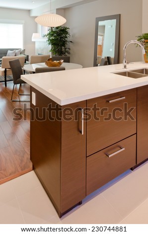 Luxury modern kitchen with dining room and living room at the back. table. Interior design of a brand new house. Vertical.
