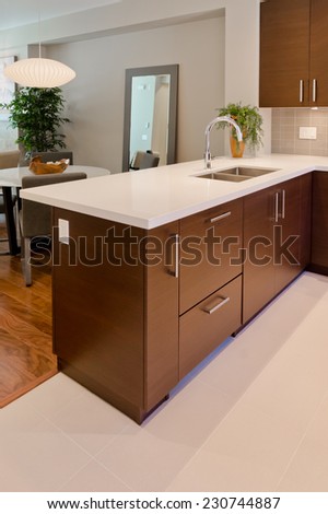 Luxury modern kitchen with dining table at the back. table. Interior design of a brand new house. Vertical.