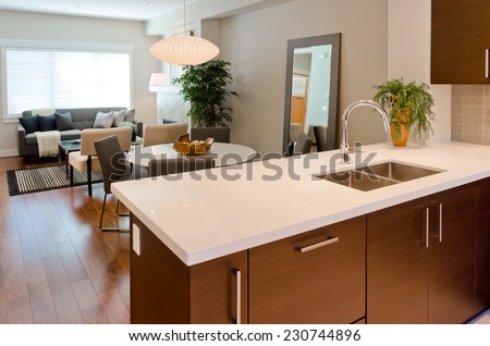 Luxury modern kitchen with dining room and living room at the back. table. Interior design of a brand new house.