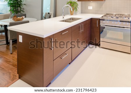 Luxury modern kitchen with dining table at the back. Interior design of a brand new house.